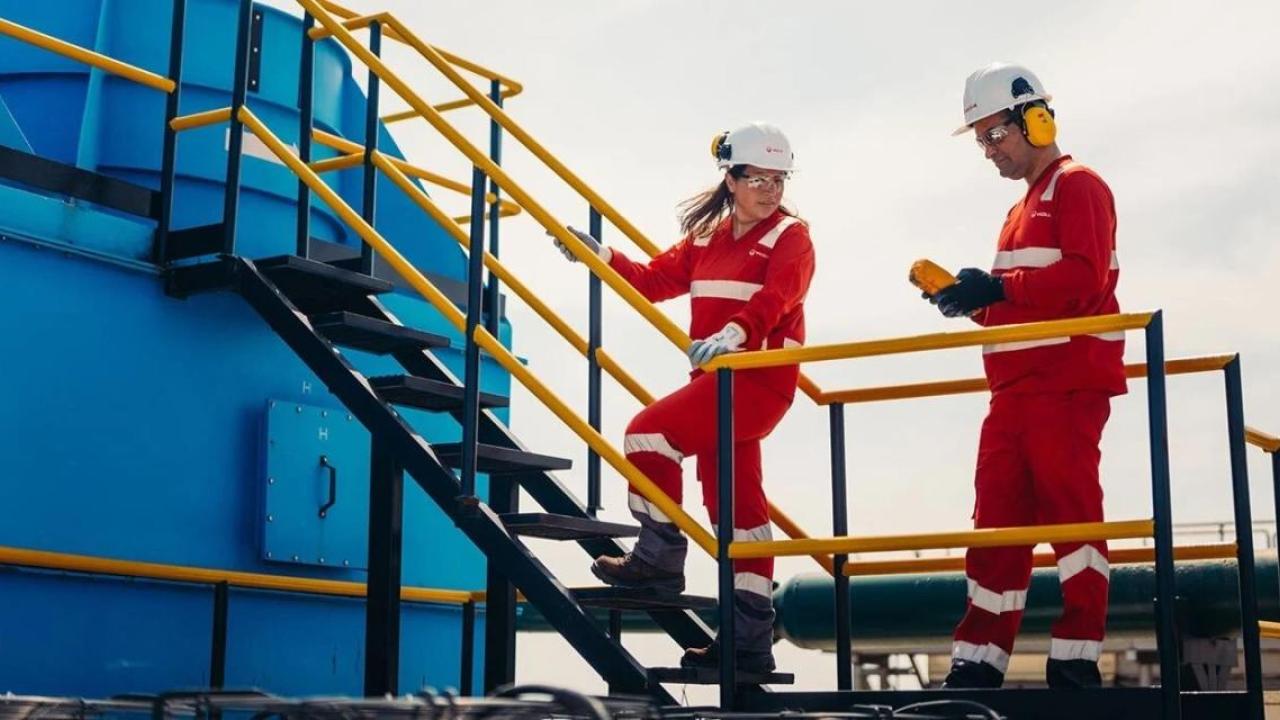 Two Veolia workers speaking to one another 
