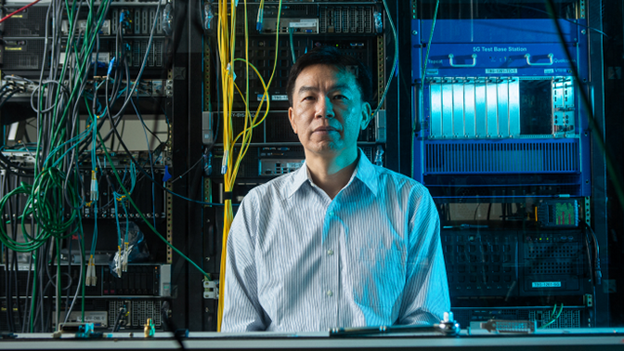 Dr. Tao Luo in front of a giant mainframe