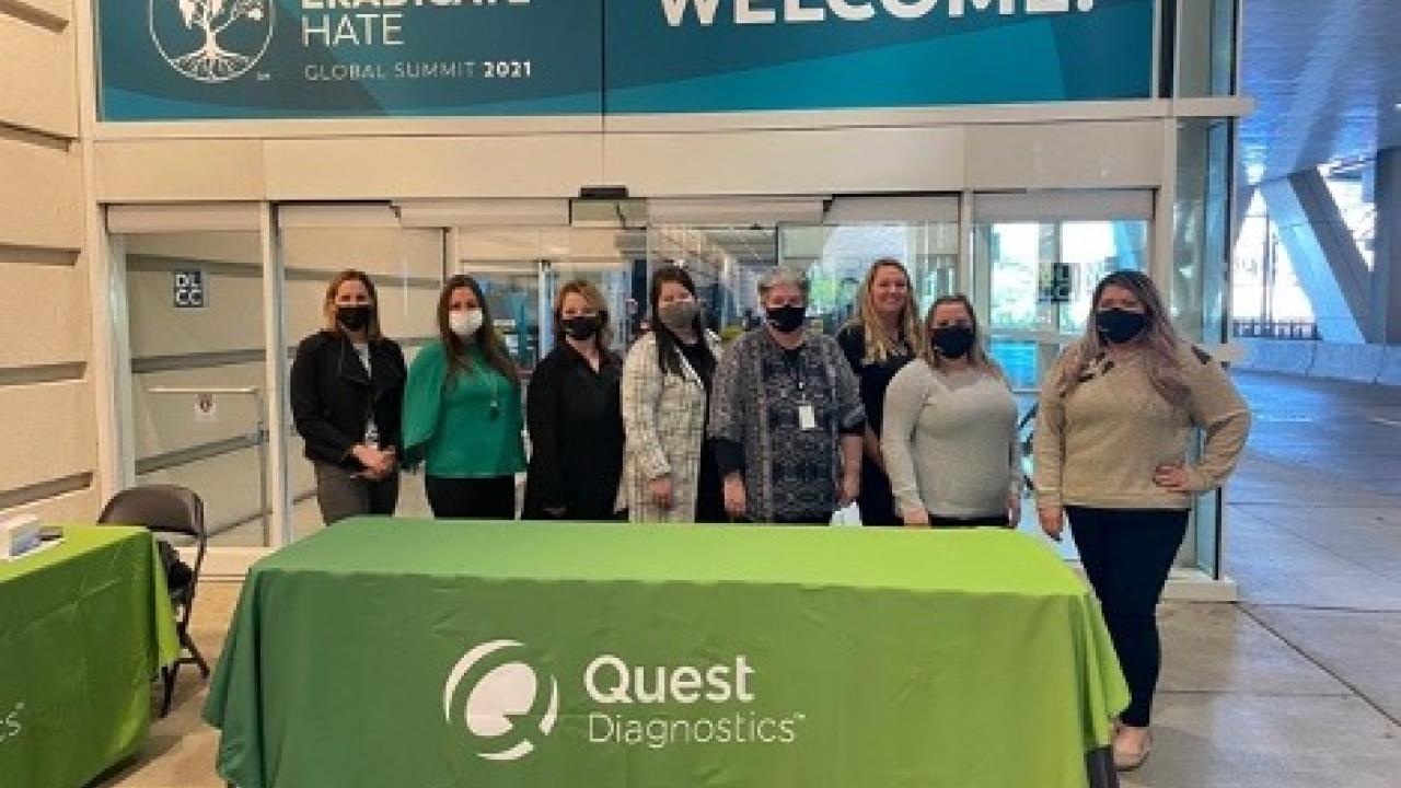 People standing by Quest Diagnostics table at conference 