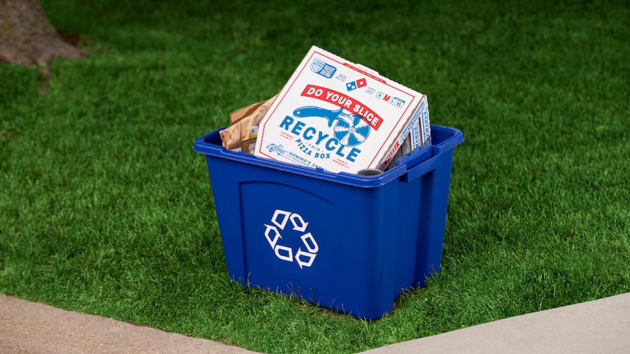 A pizza box inside a recycling container 