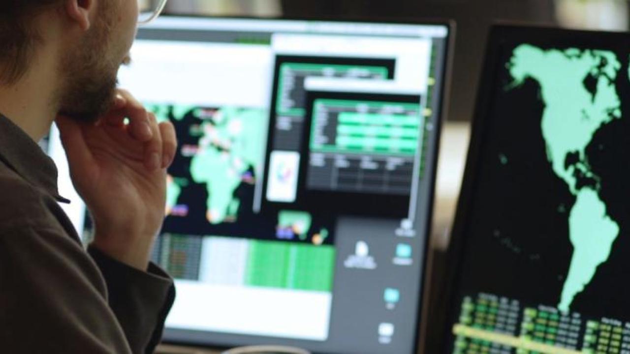 Side angle of someone looking at a computer screens featuring maps