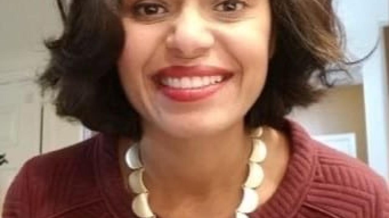 Photo of Renu Zunjarwad in a red sweater