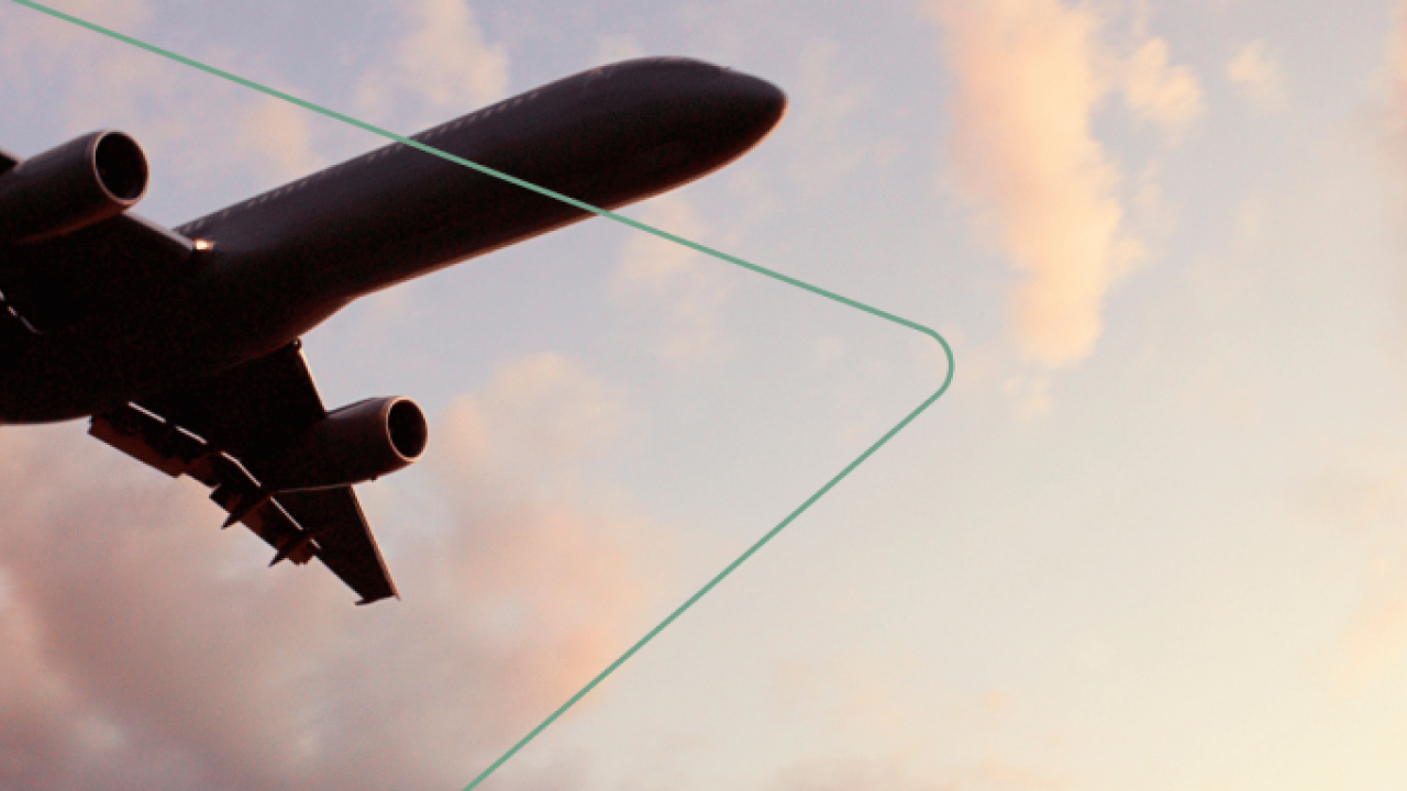 An airplane in the sky, a setting sun off screen.