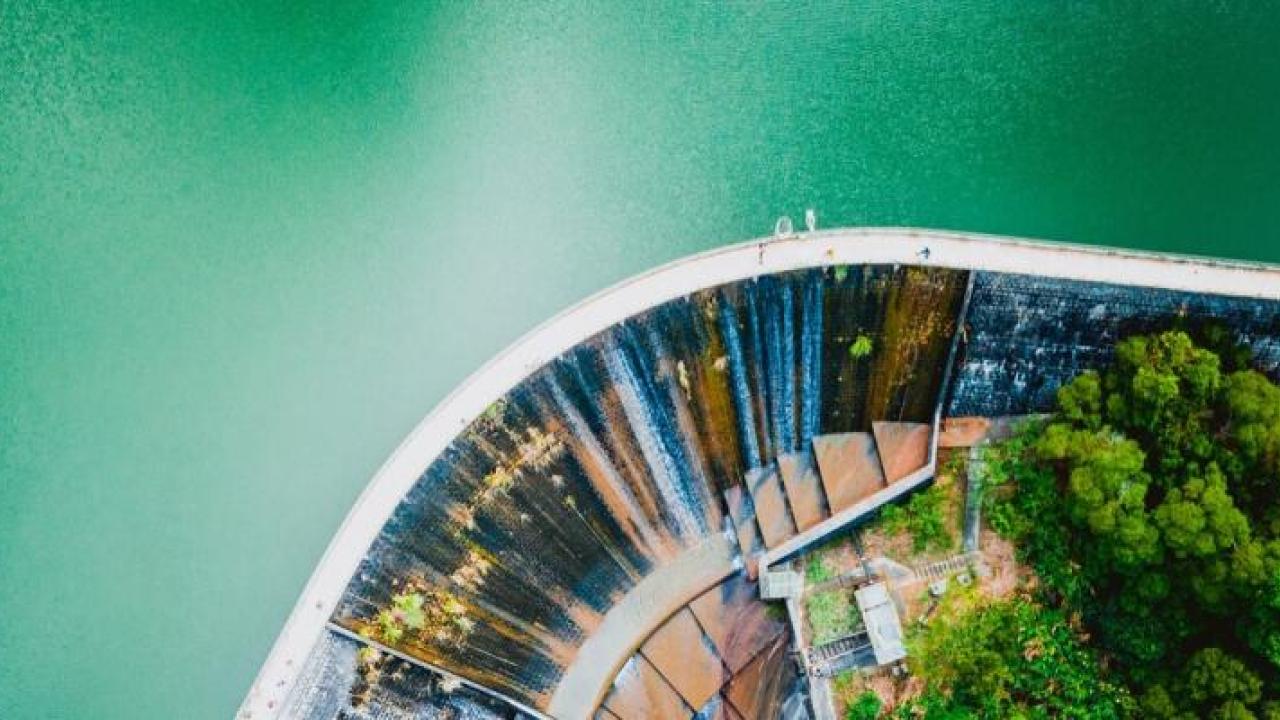 Aerial view of a body of water with a dam and walkway on top.