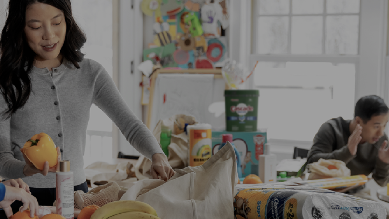 people in a kitchen unpacking a shopping bag