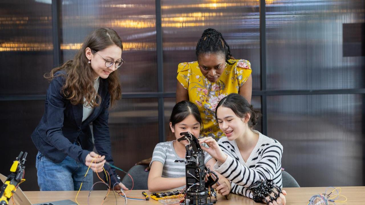 Tw girls building machines with instructors