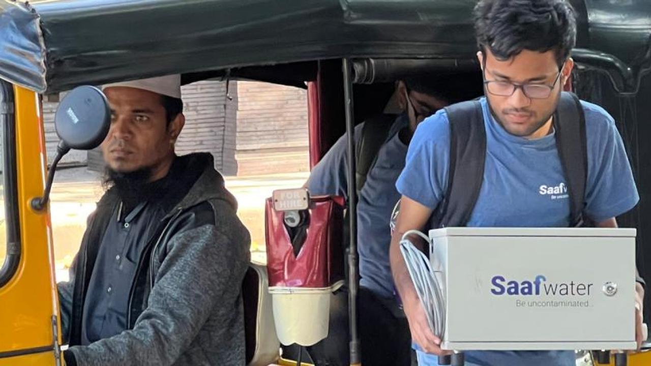A person stepping out of a taxi carrying a Saafwater box.