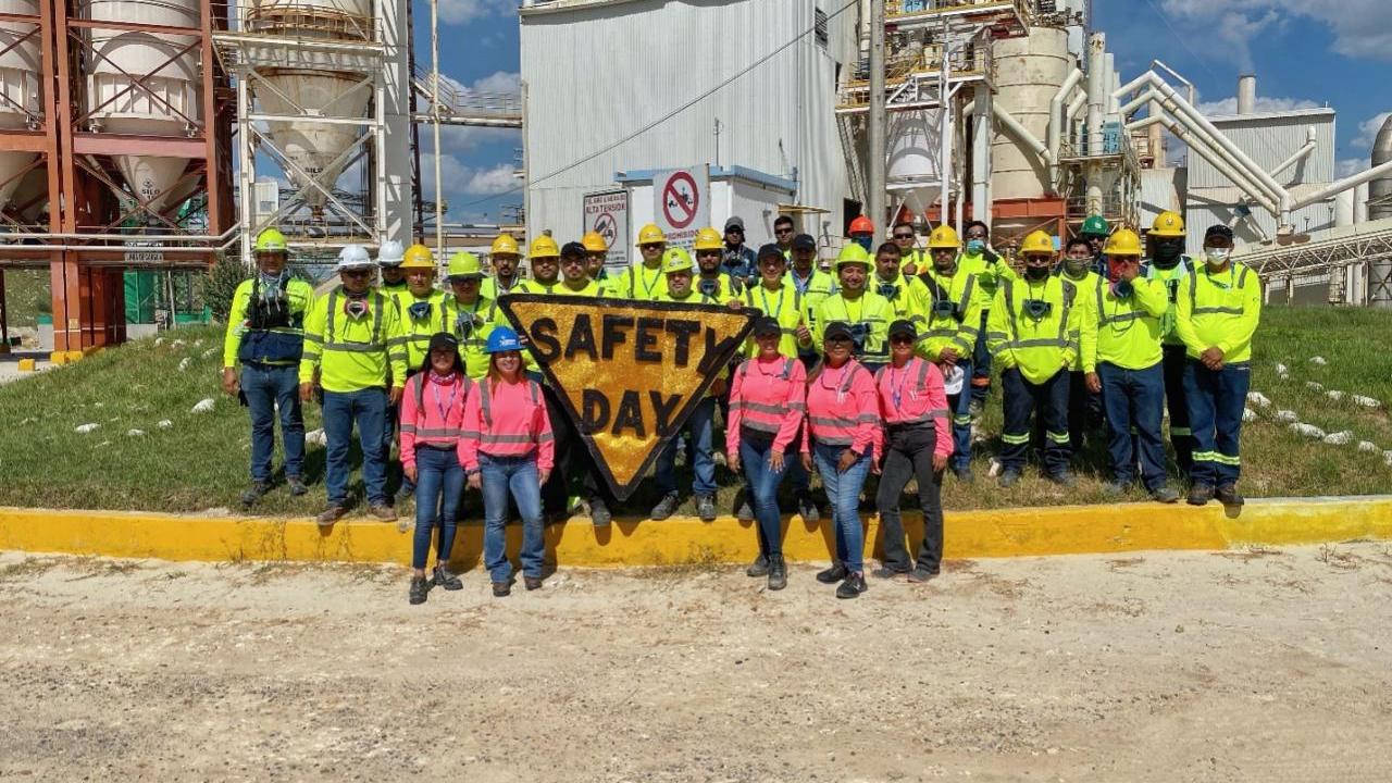 Group of employees stood around a sign that reads 'Safety day'
