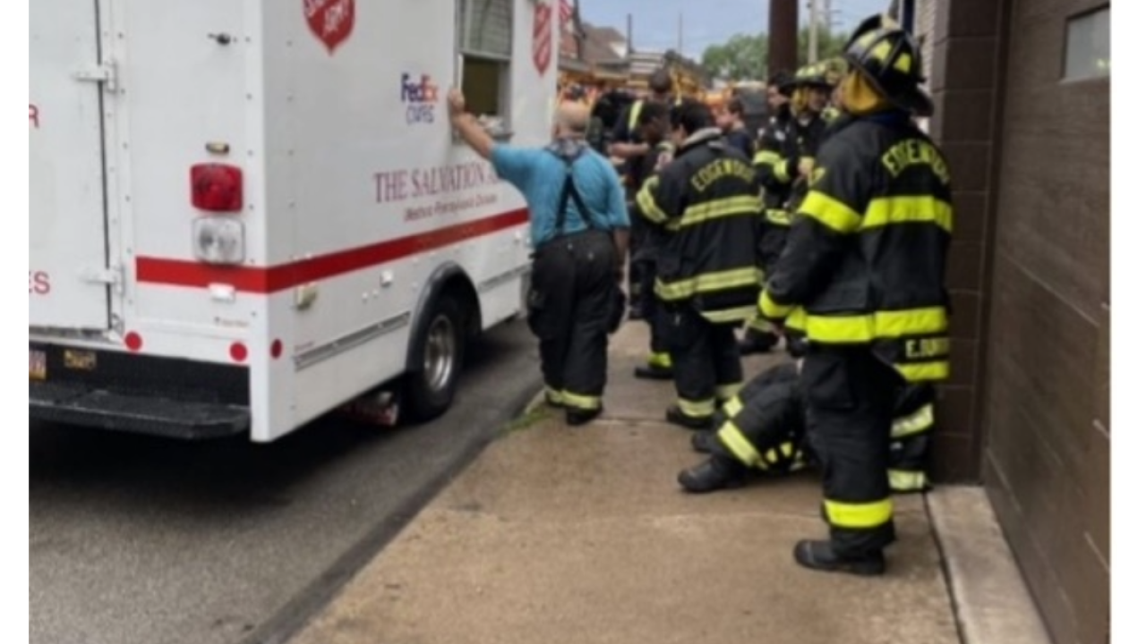 Fire personnel standing by a FedEx and Salvation Army truck