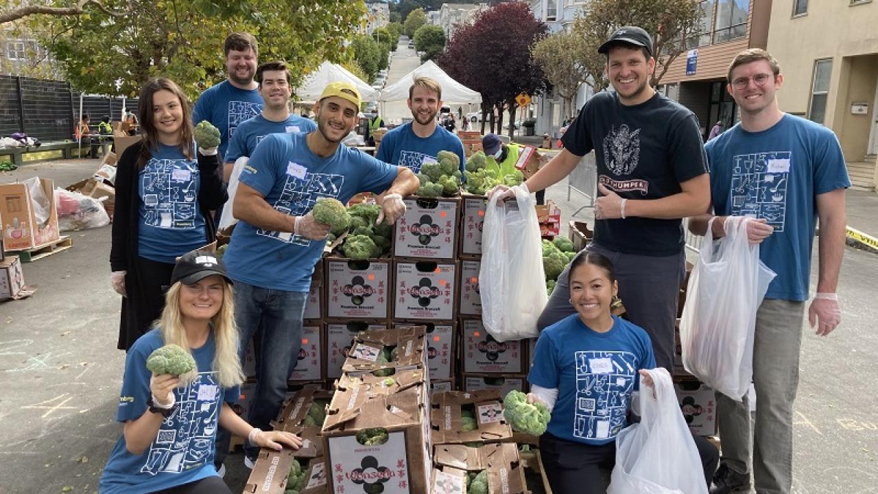 Volunteers pose with boxes of food at a food bank