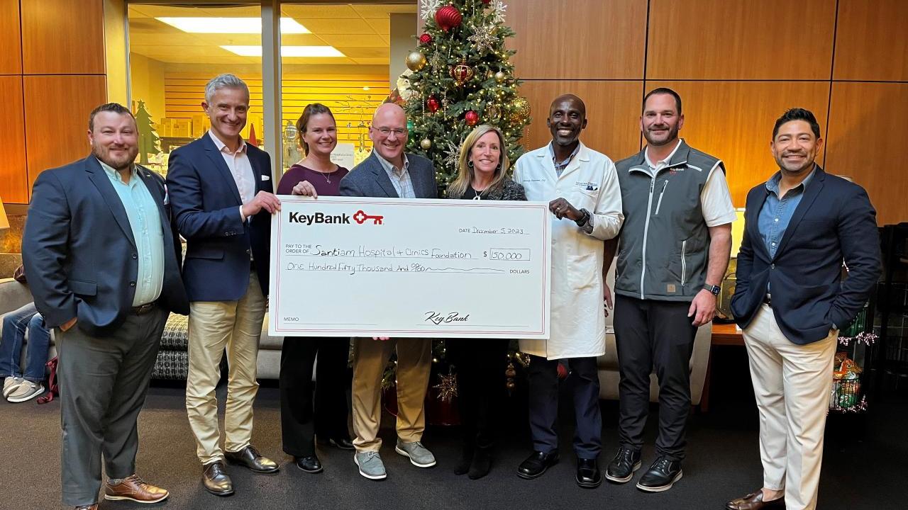People standing together, holding a check from KeyBank