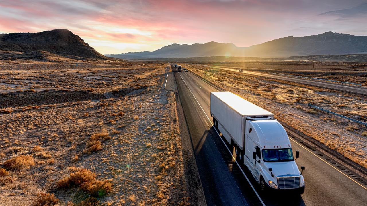 truck driving in the desert at sunset