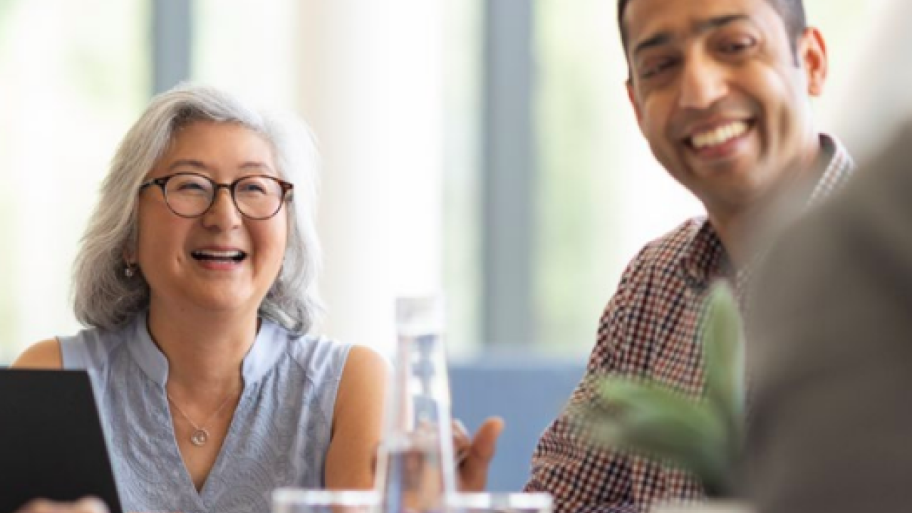 Woman and man smiling in a meeting