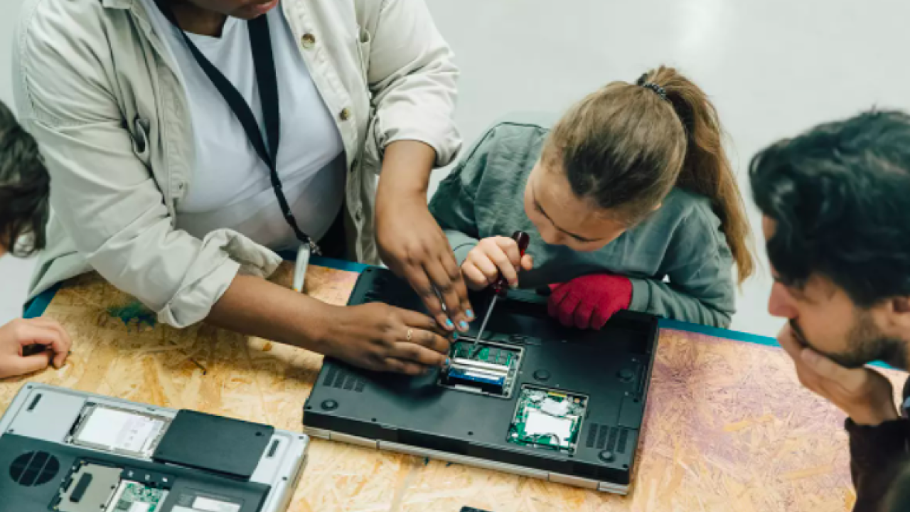 Students taking apart a laptop computer