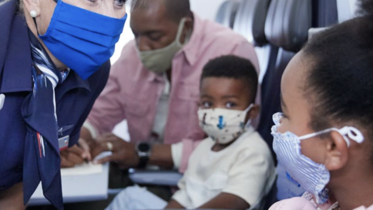 flight attendant assists a Black child