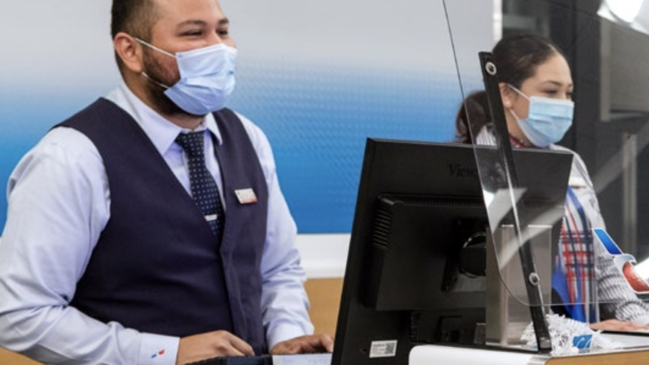 American Airlines gate agents wearing masks and standing behind plexiglass