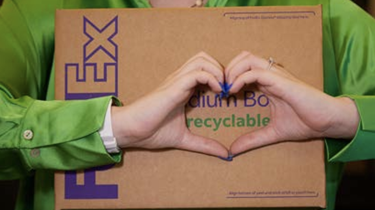Person making a heart with their hands over a FedEx box