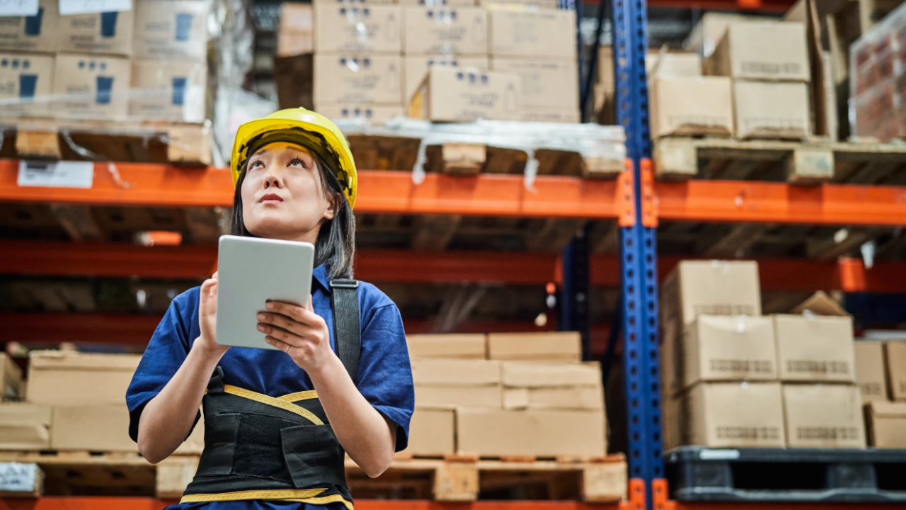 Worker Using Tablet in Warehouse Aisle