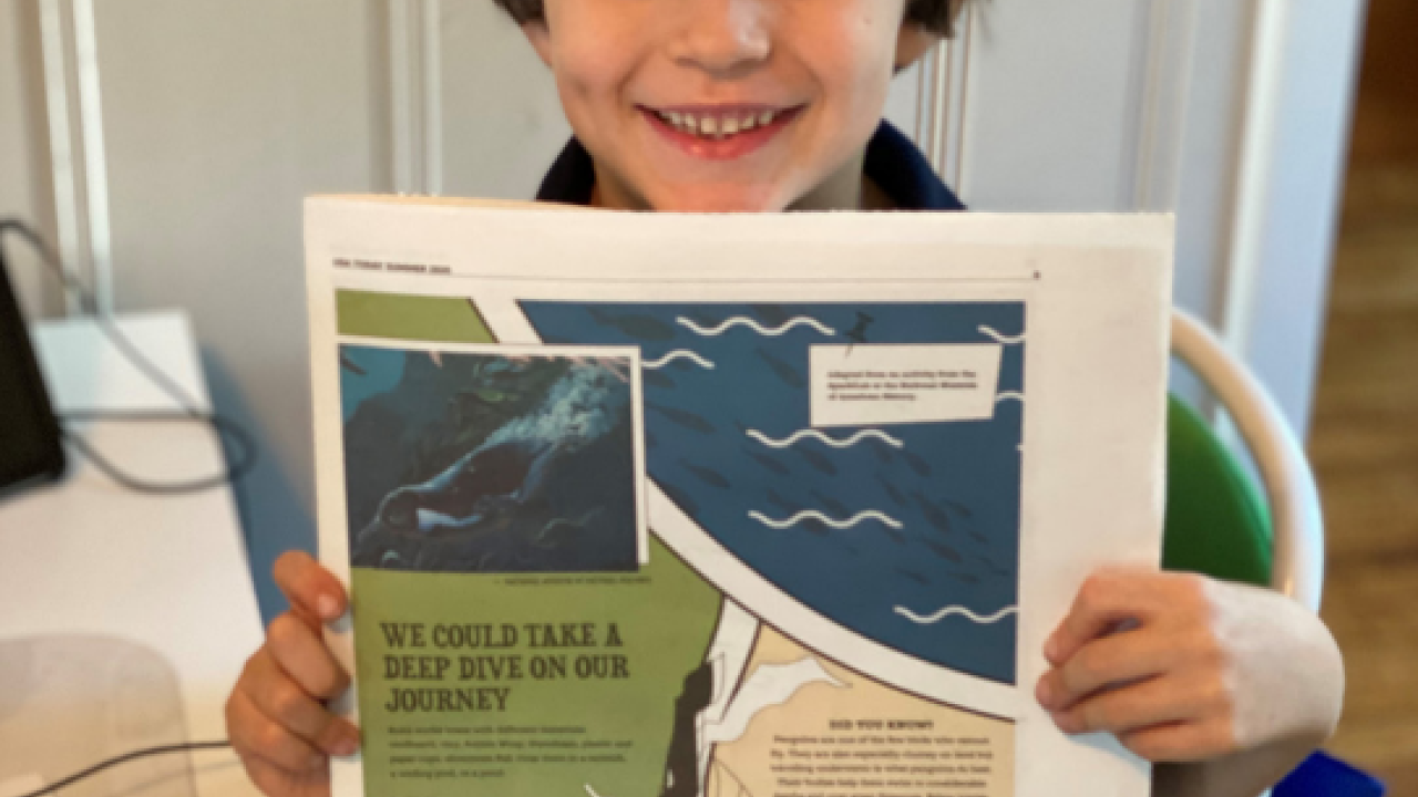 Boy holding up a learning guide