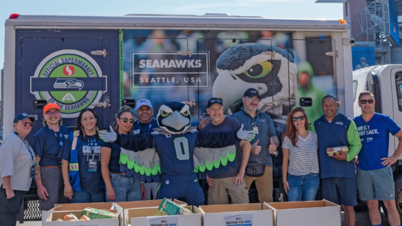 Group of people posing with food donation boxes