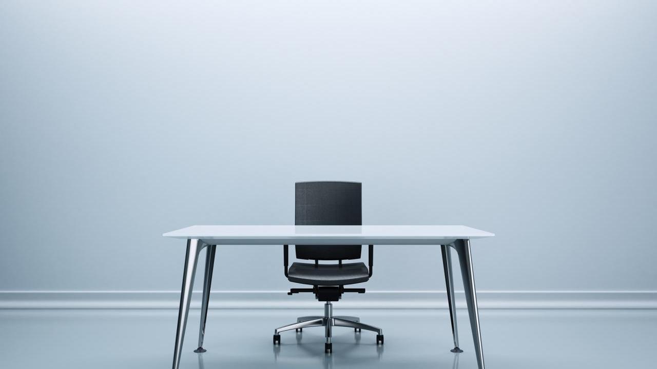 Desk and chair in the center of an empty room