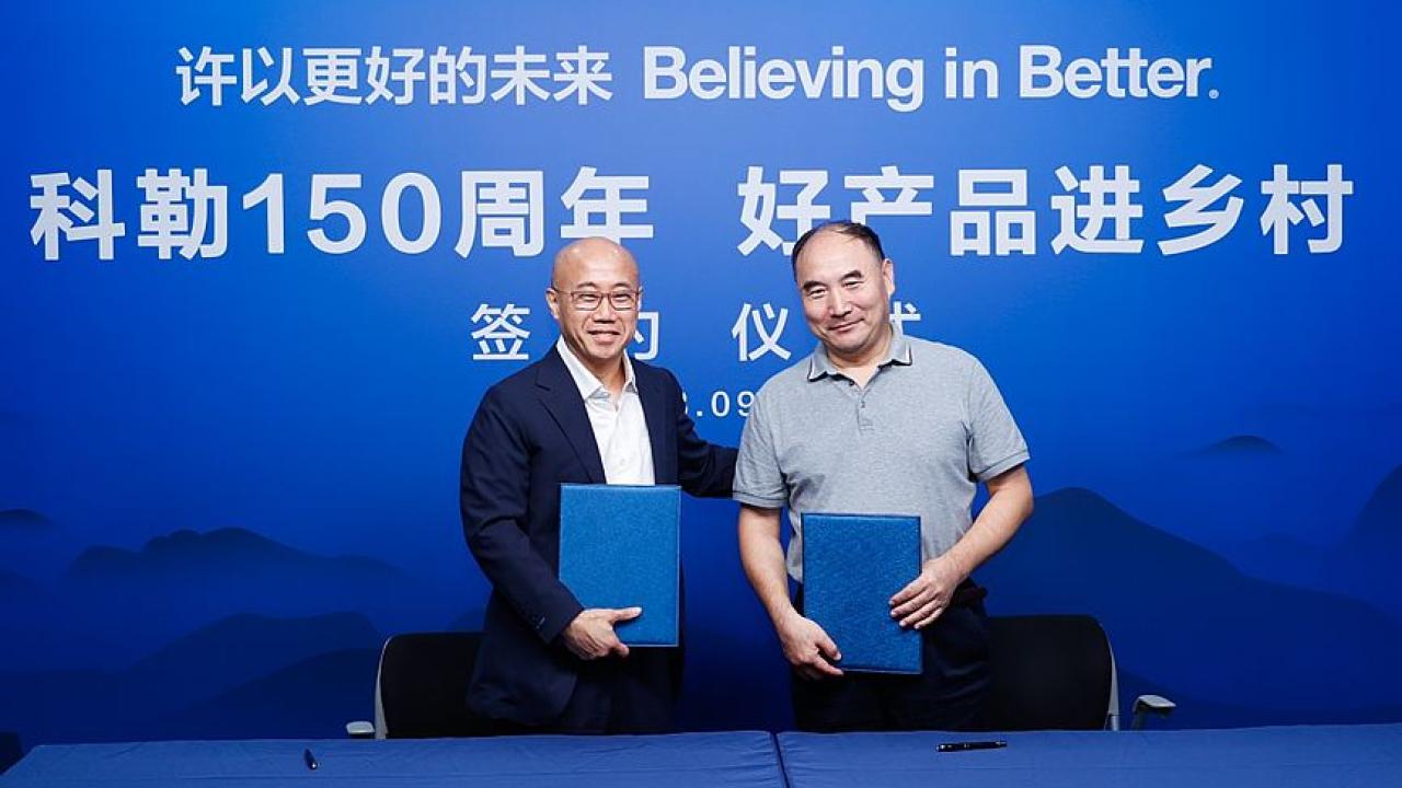 Two people stood together against a blue backdrop 