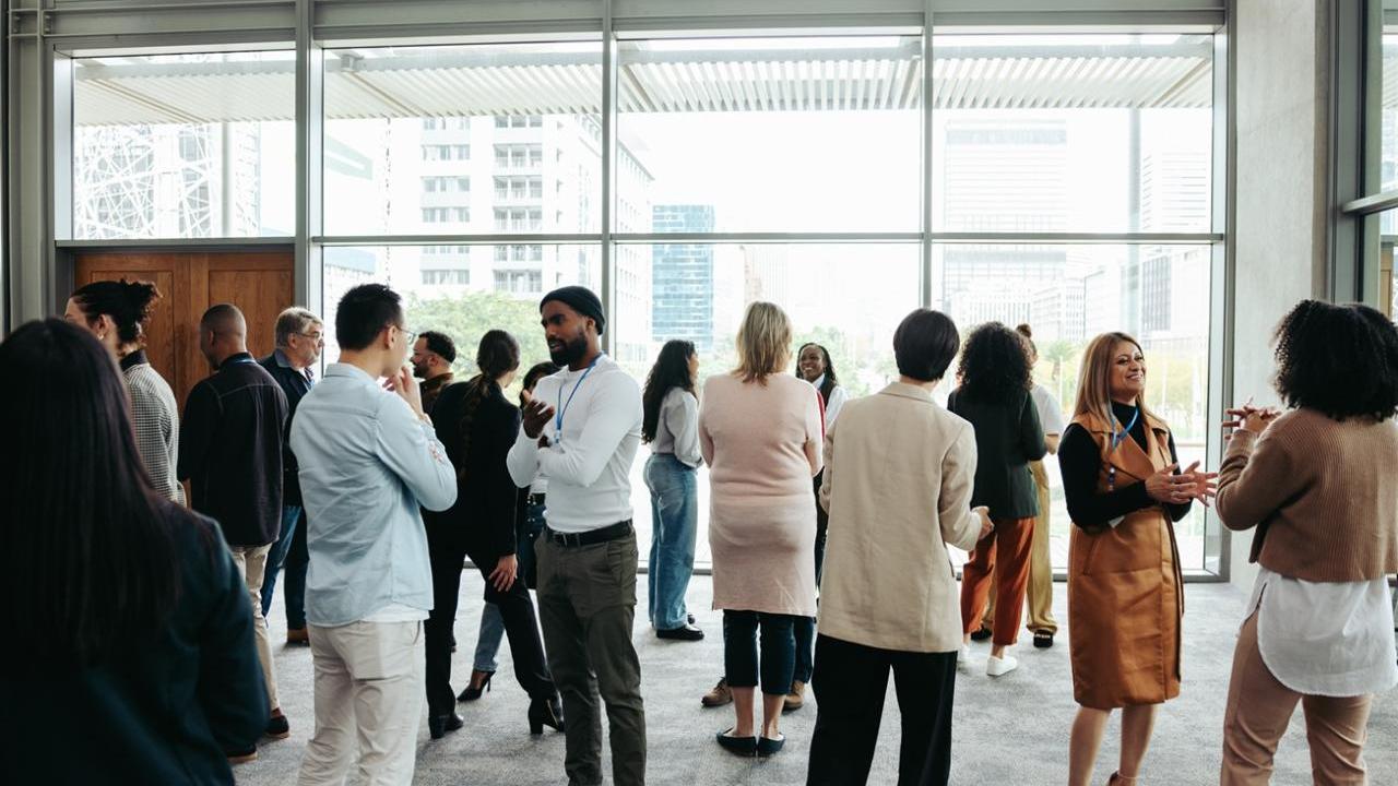 Corporate crowd engaging in teamwork during business event in modern office space