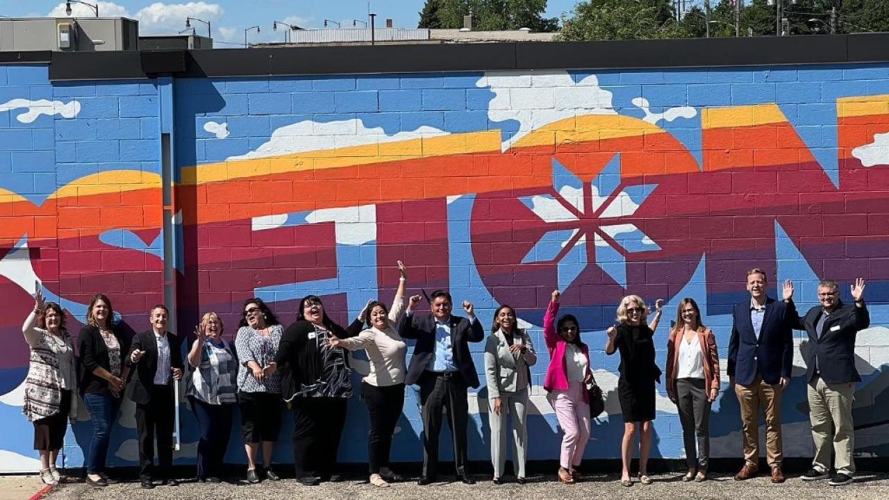 Group of people stand in front of a large wall mural in Sisseton, South Dakota