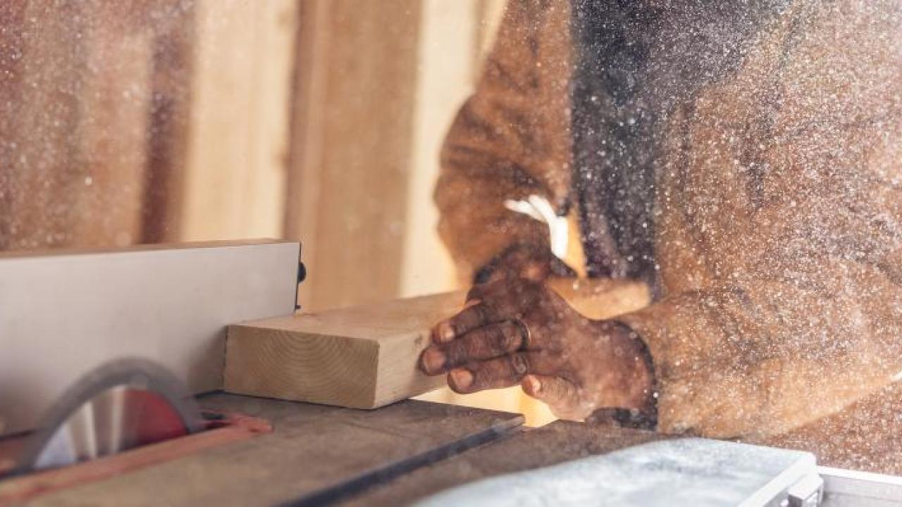 A person cutting some wood using a machine 