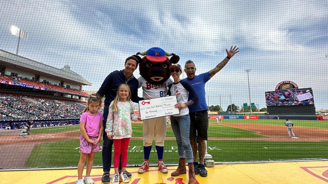 Slow Roll Buffalo donation shown with Buffalo Mascot and a family.