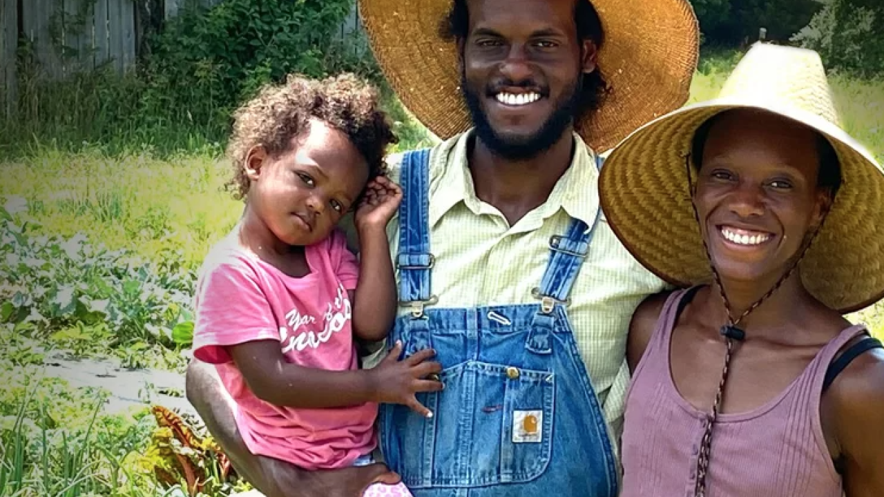 2 parents smile while holding their child