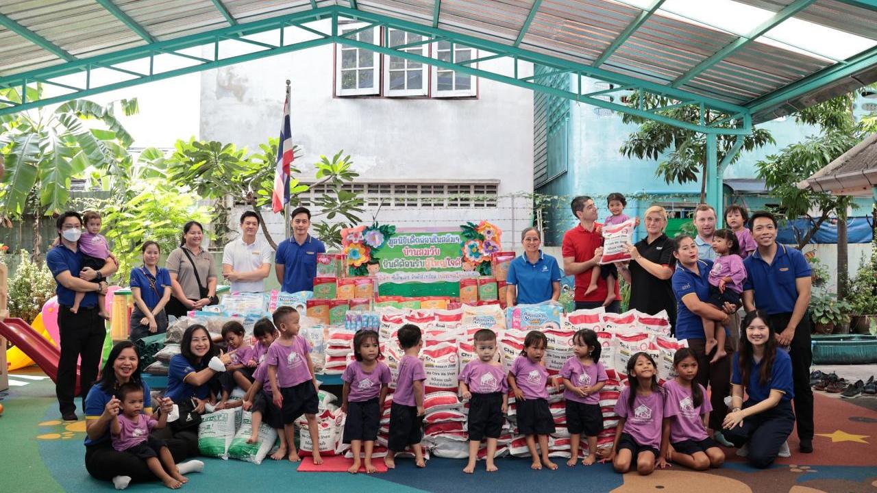 Adults and young children stood around bags of donation bags