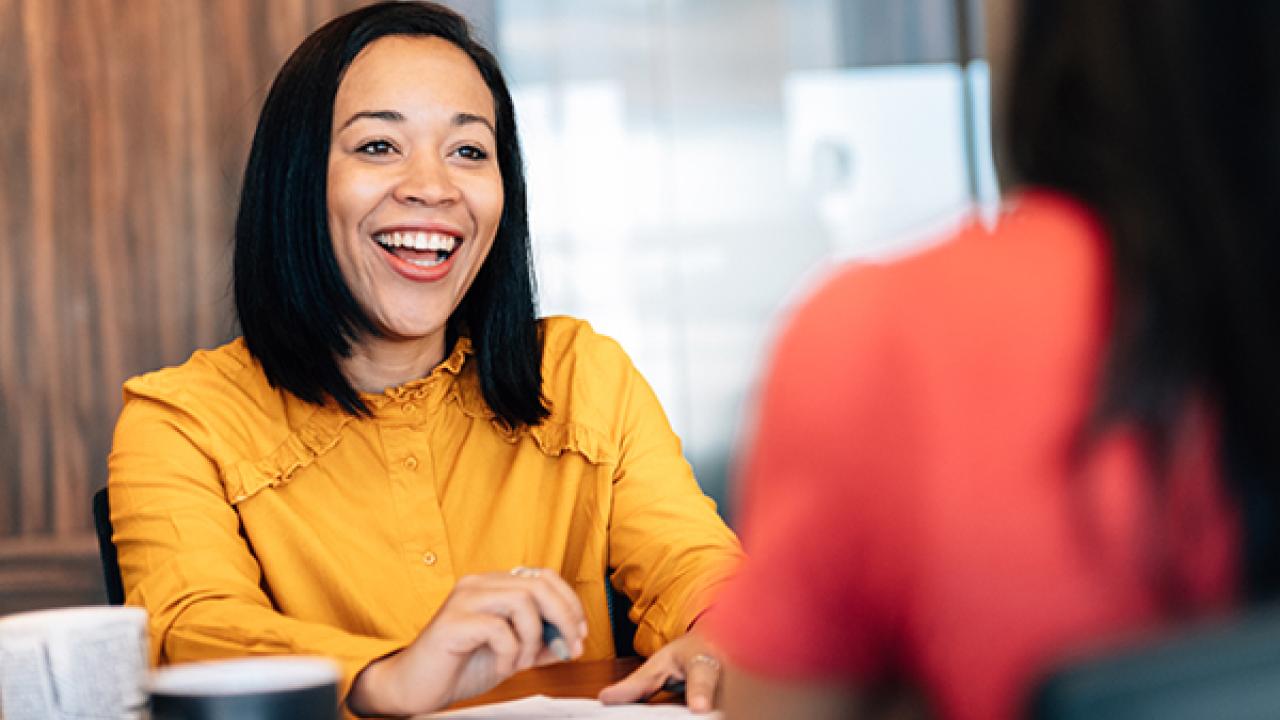 Female business owner shown speaking with an associate.
