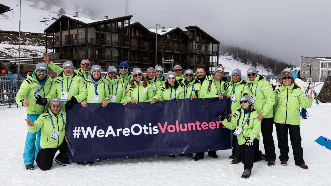 Group of Otis volunteers holding a We Are Otis banner.