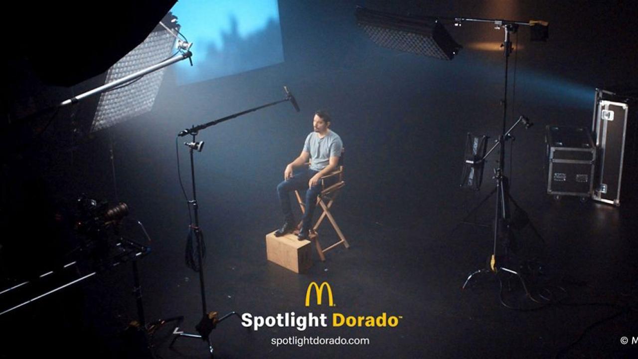 Person sat on a film set under a spotlight