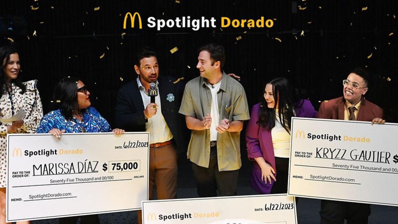 McDonalds logo and "Spotlight Dorado" above three award recipients and presenters holding large checks as confetti falls.
