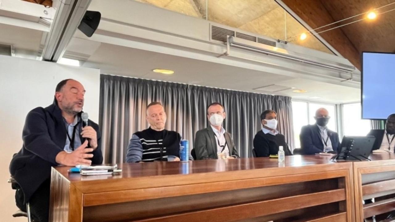 six people at a long table, running a meeting
