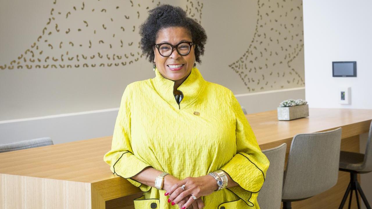 Stephanie A. Smith leaning against a table