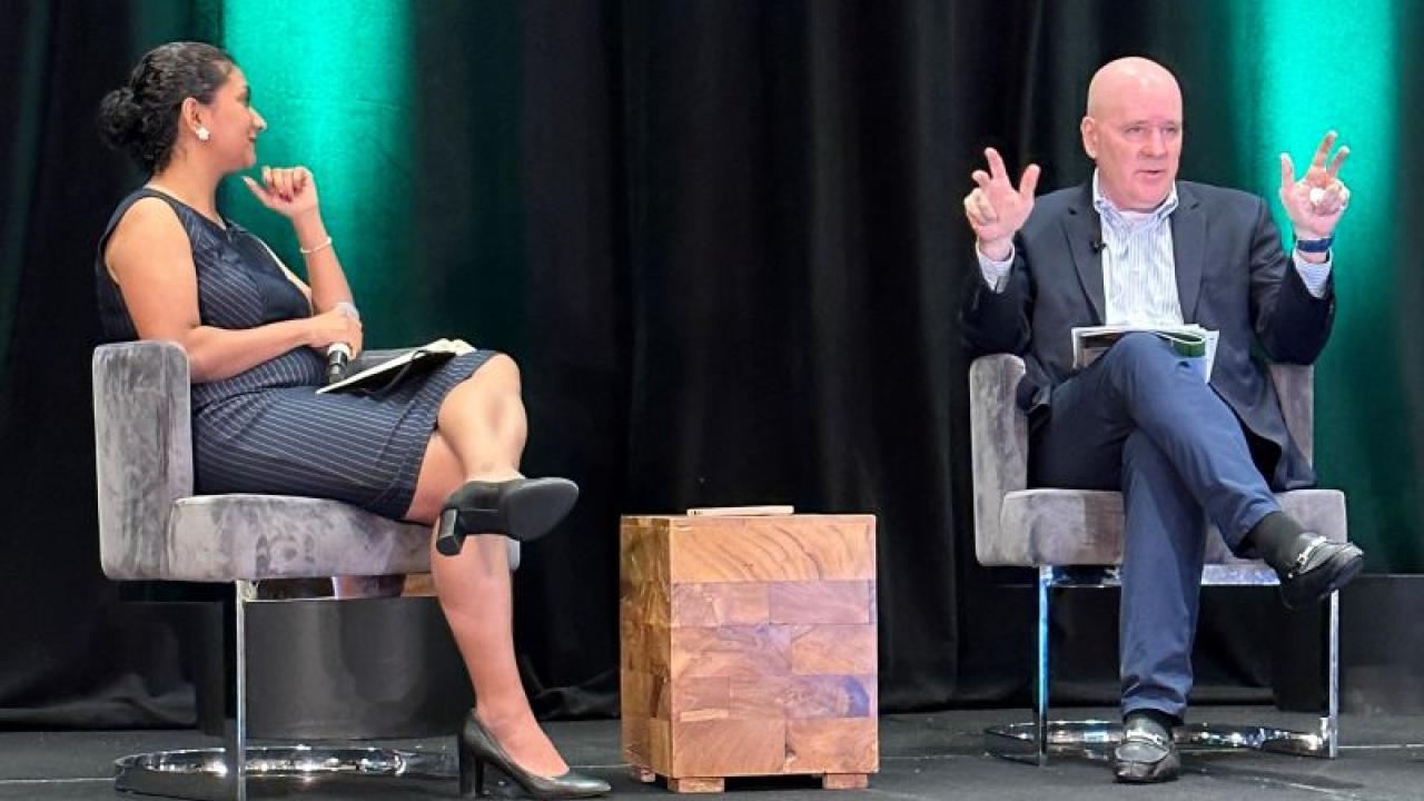 Steven Fradkin and another person seated in chairs on a stage.