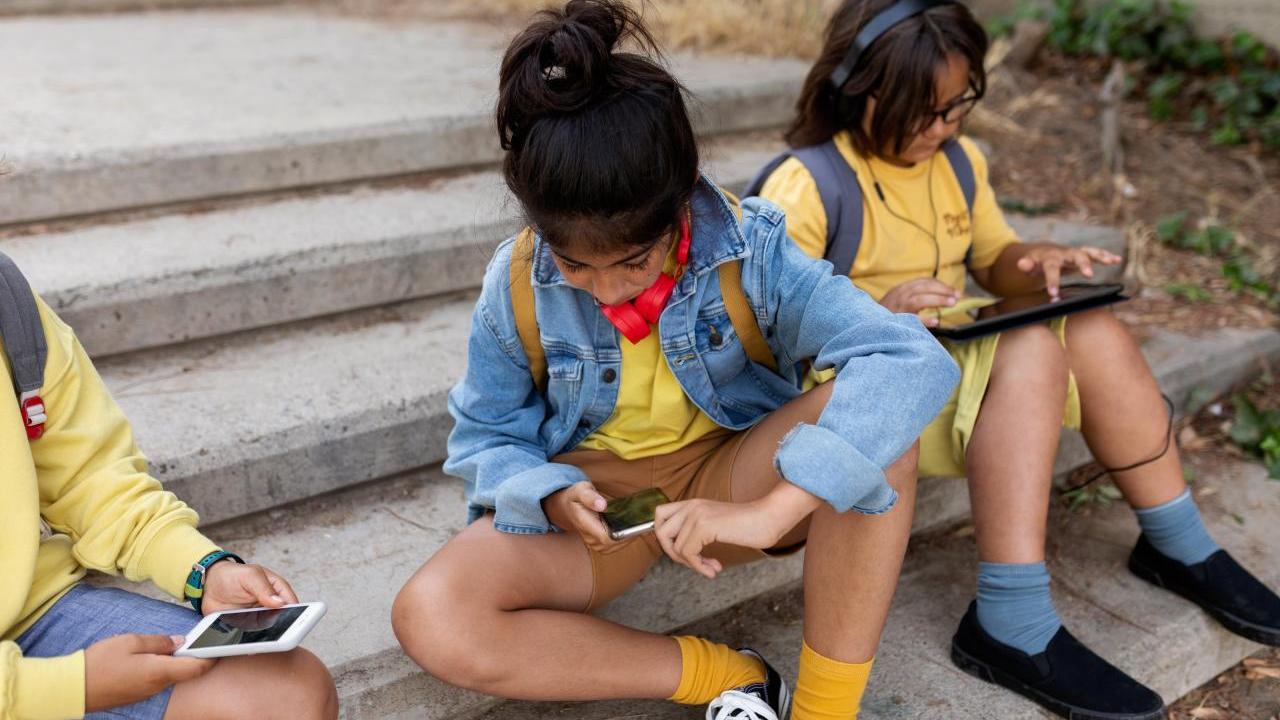 Students in uniform on their devices