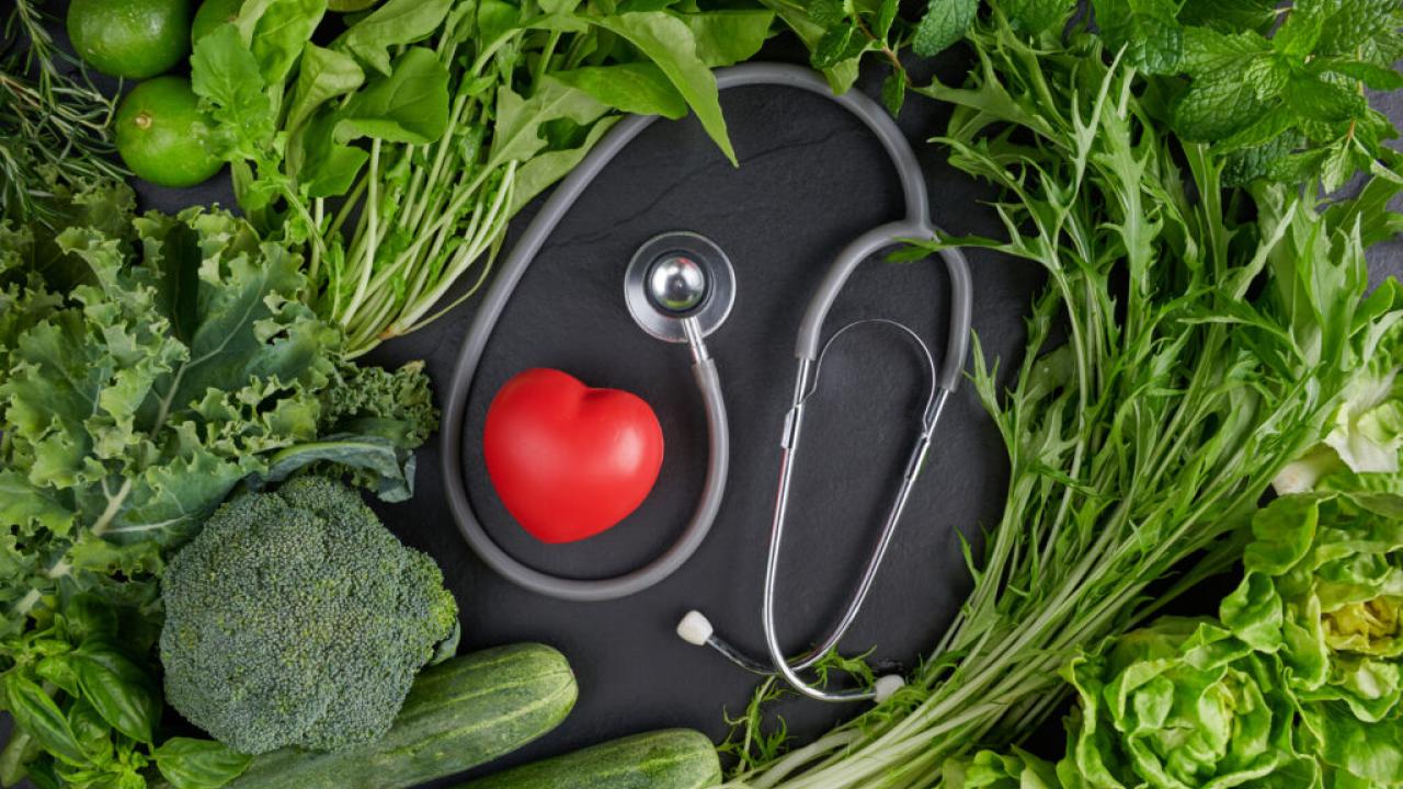 A stethoscope and a small heart are shown with produce.