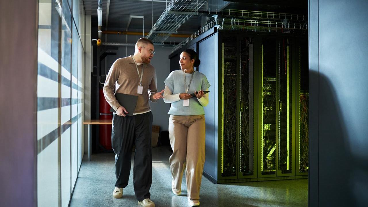 Two workers walking through a data center