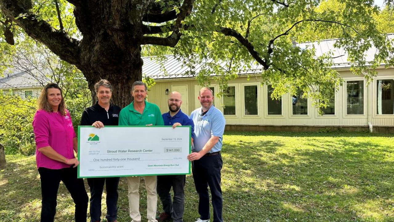 Group of Stroud Water Research Center team and Green Mountain Energy team pose with a $141,000 sustainability grant check at Stroud Water Research Center facility in Avondale, PA.