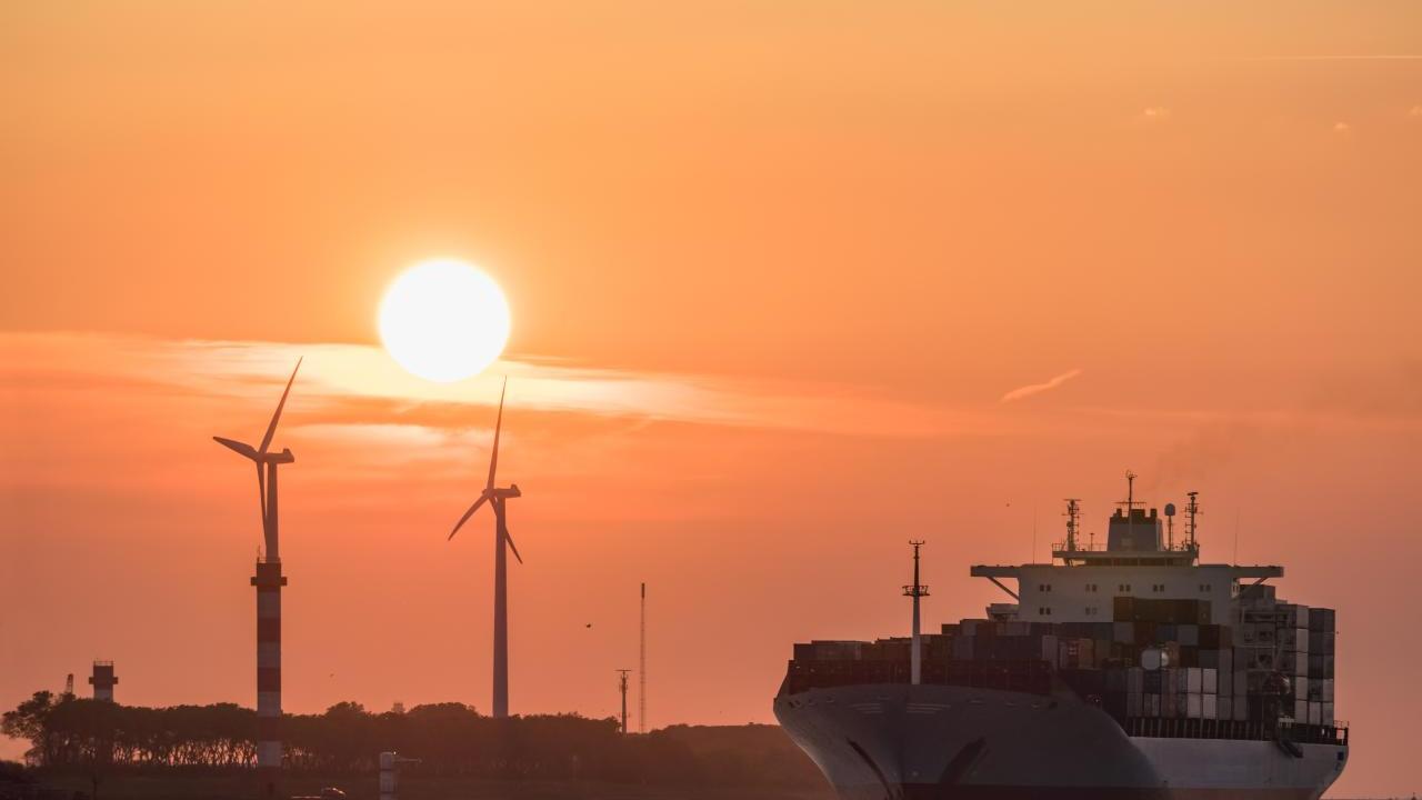 Container ship coming into port at sunset