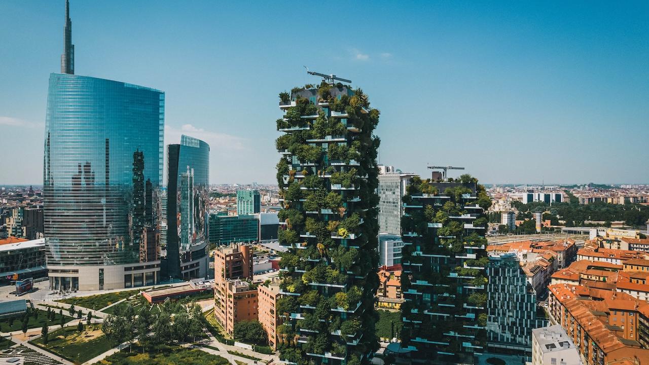 Two buildings shown with greenery.
