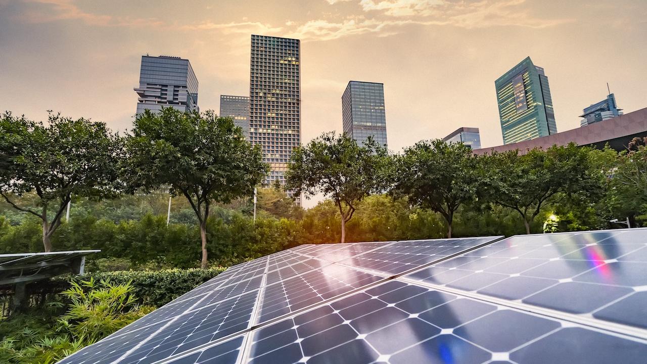Solar panel array with a cityscape in the background.