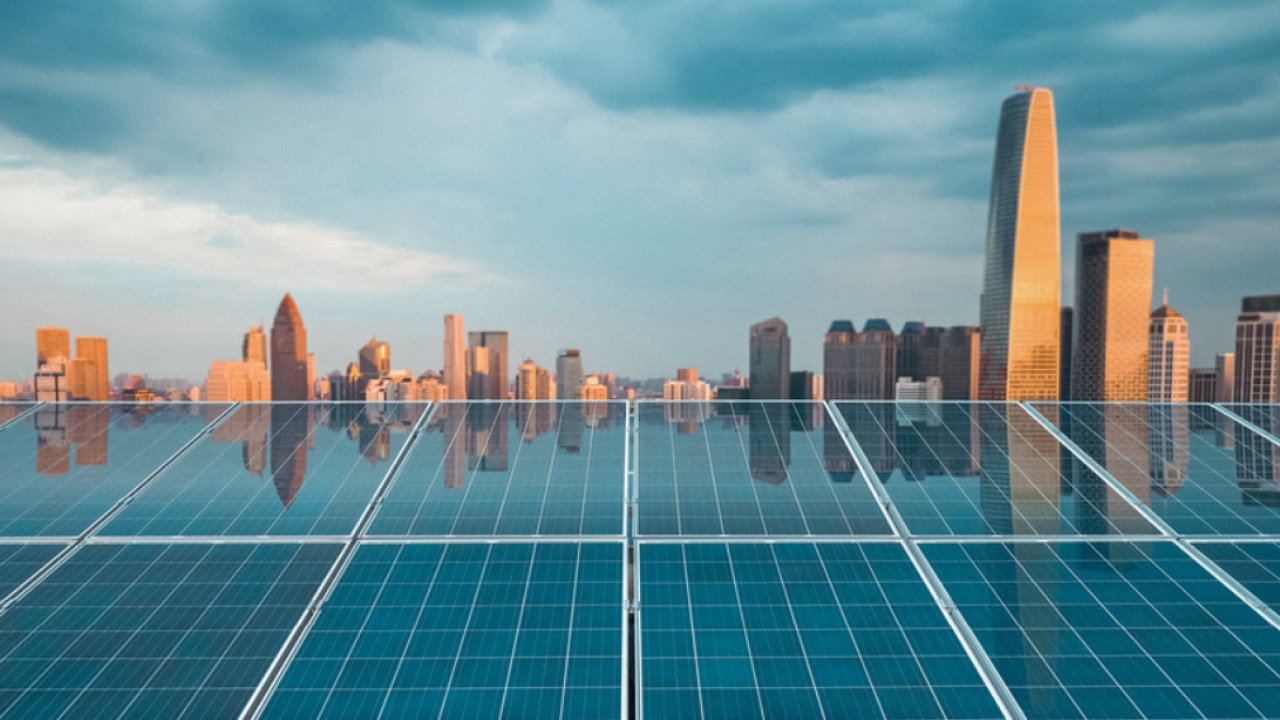 Solar panels shown on top of a building in a city.