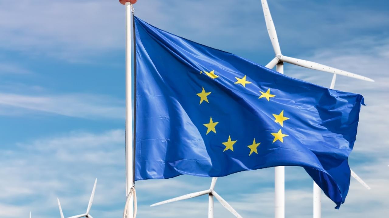 EU flag flying in front of wind turbines
