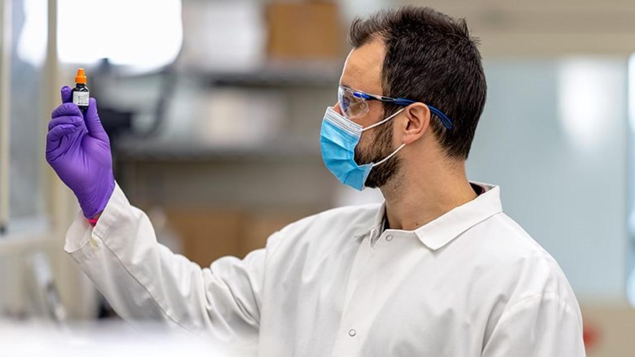 Scientist looking at a vial