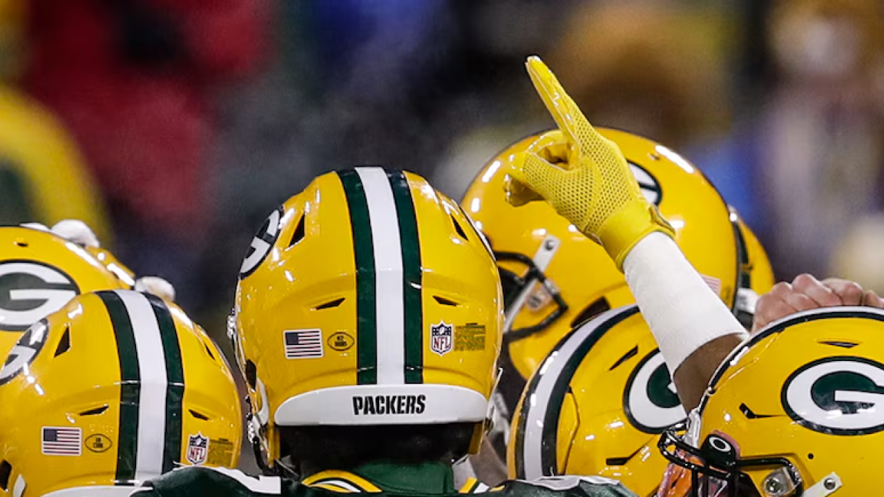 Green Bay Packers shown in a huddle.